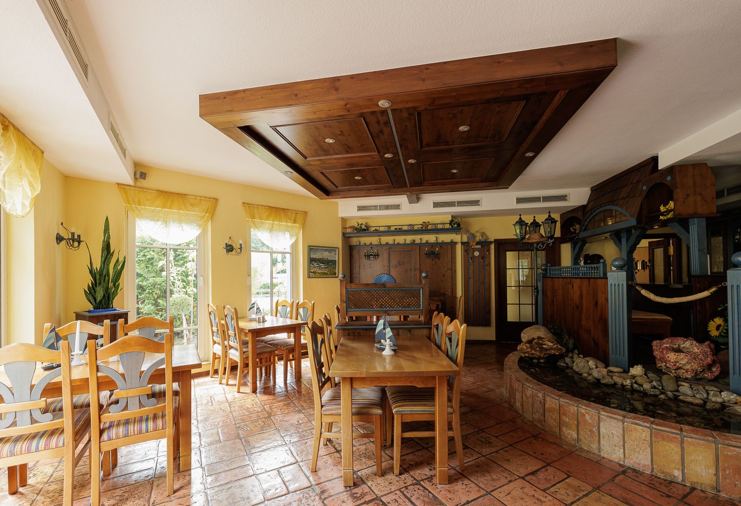 Restaurant in in dunklem und gelauchten Holz mit Fliesenboden in gemütlichem Ambiente
