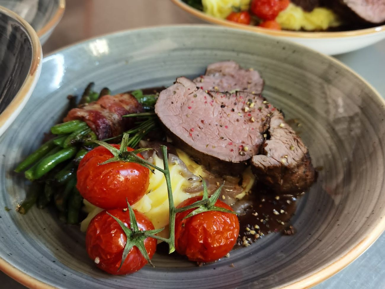 Fleischgericht auf runden tiefen Tellern angerichtet