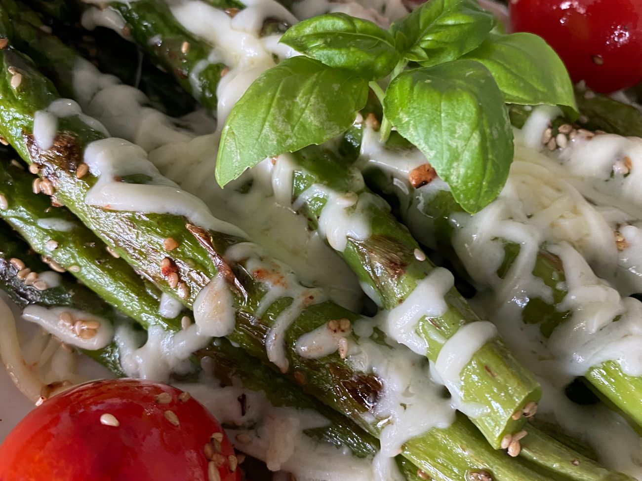 Spargelgericht mit Tomaten und Basilikum garniert