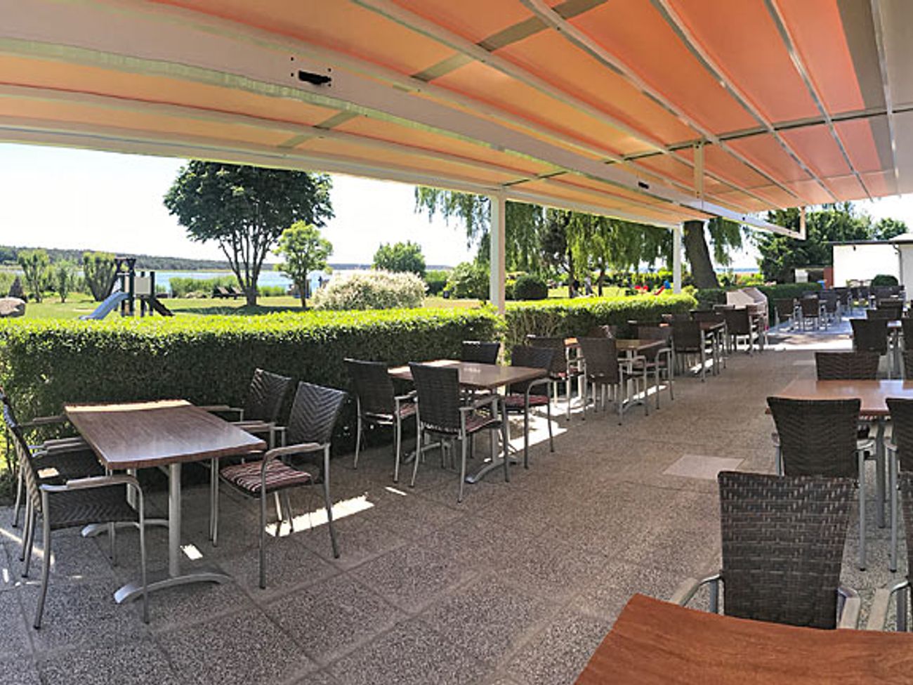 Terrasse eines Restaurants überdacht mit einer großen Markise