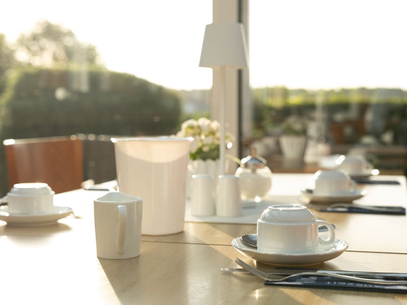 Für das Frühstück eingedeckter Tisch mit Blick auf die Terrasse