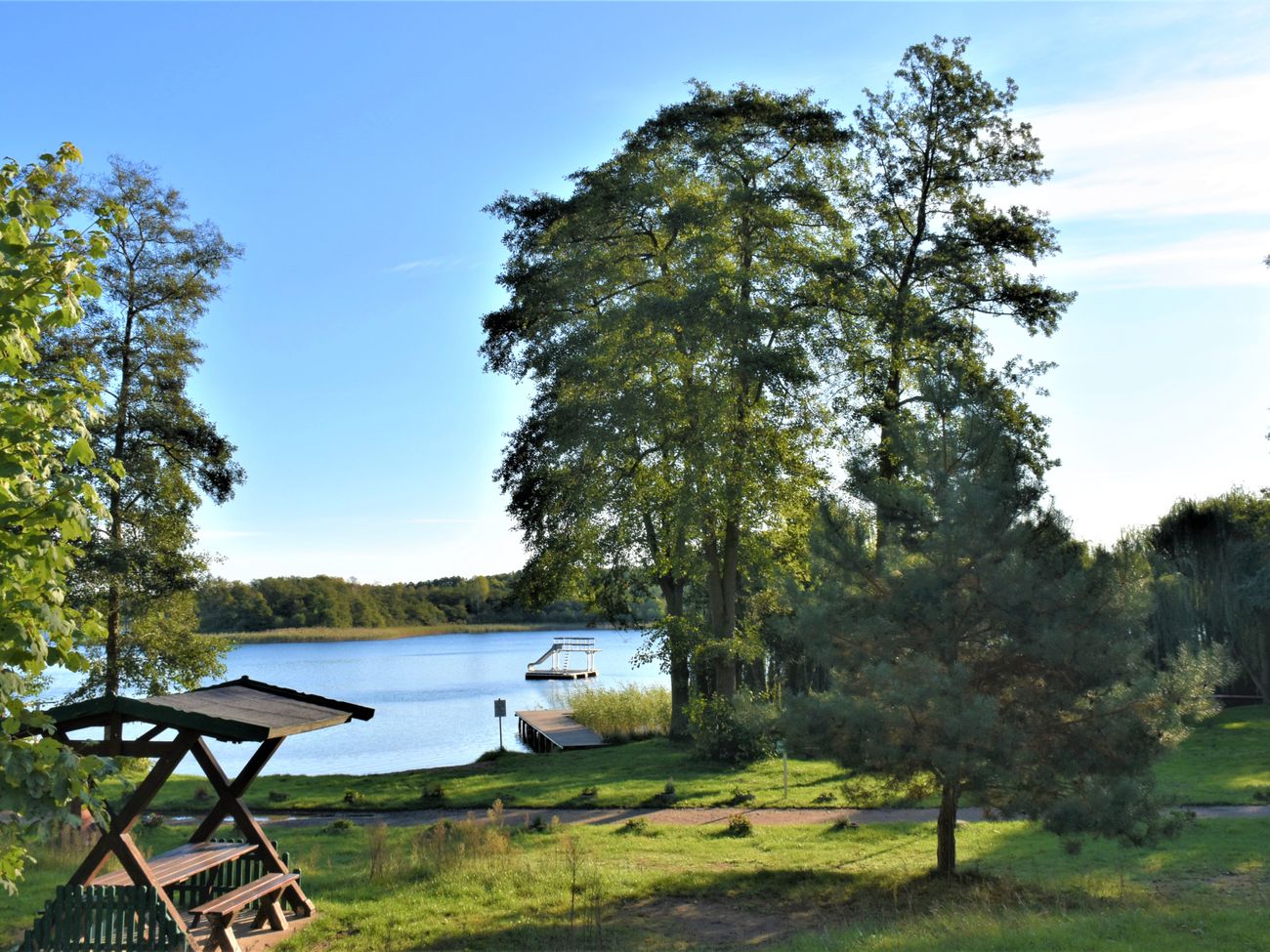 Blick auk einen blauen See, davor ein paar Bäume