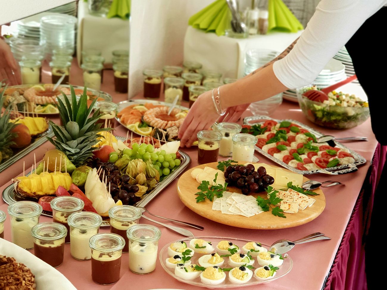 angerichtetes Buffet mit Käseplatten, Obsttellern und kleinen Gläsern mit Nachtisch