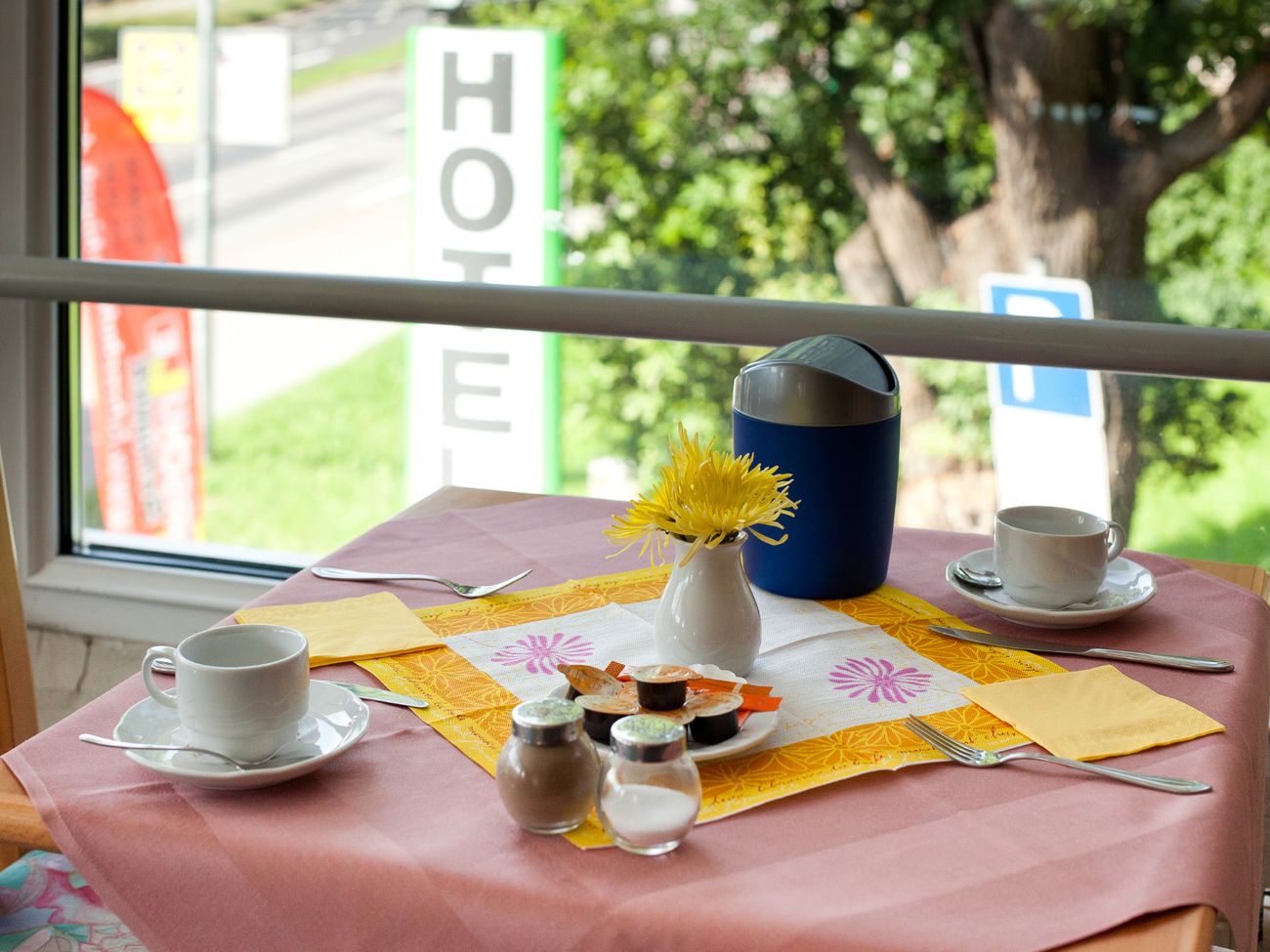 Eingedeckter Frühstückstisch mit Kaffeetassen und Besteck