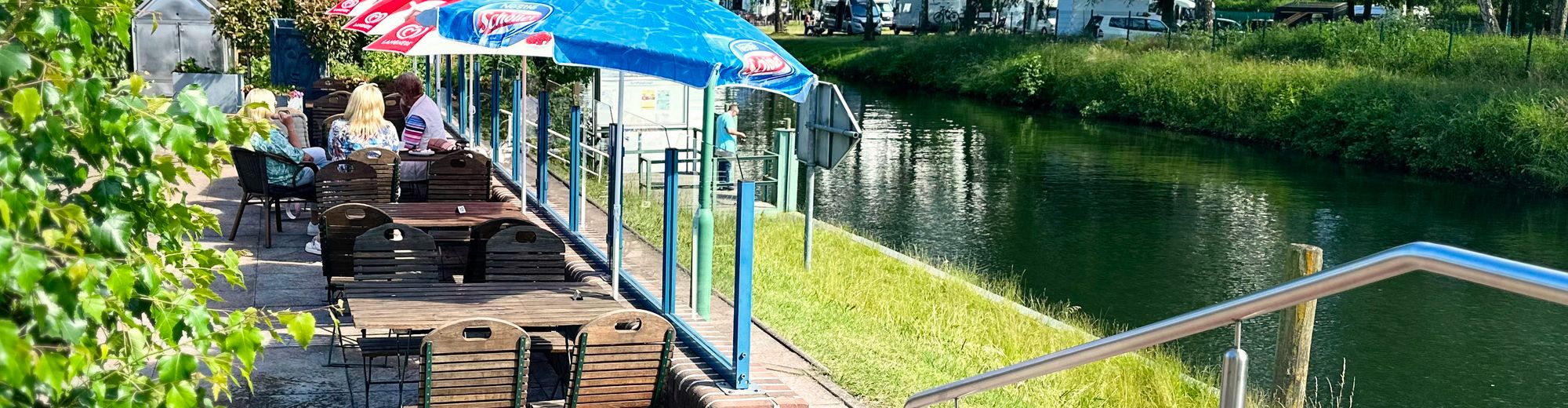 Terrasse des Lenzer Krugs mit Sonnenschirmen direkt am Lenzer Kanal