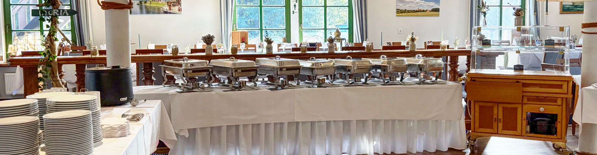 warmes Buffet, im Hintergrund eine lange Tafel