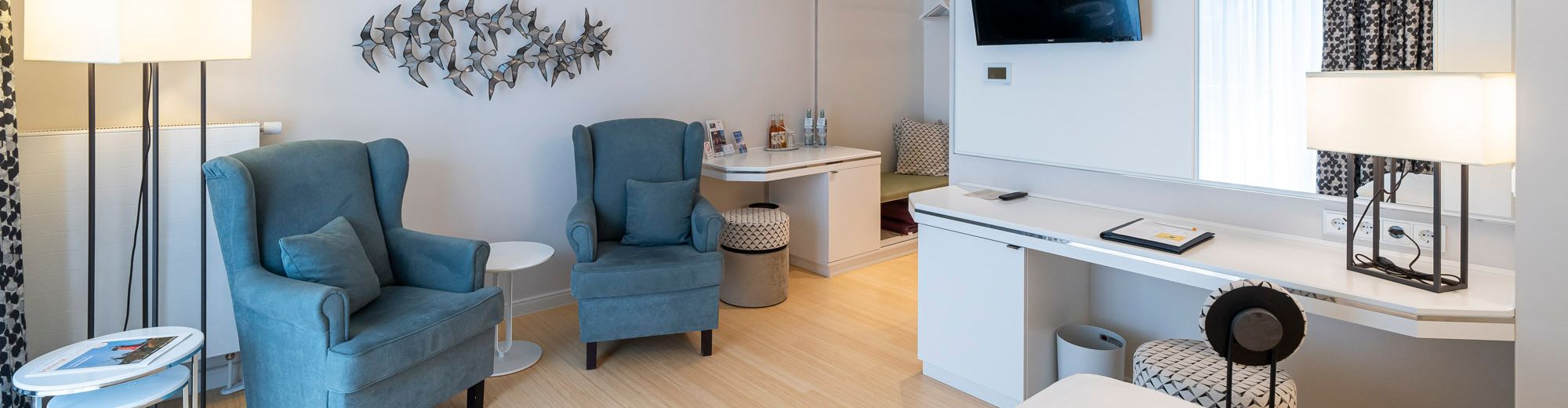 Doppelzimmer in Ausstattungslinie weiß mit weißem Mobiliar und grauen Polstermöbeln