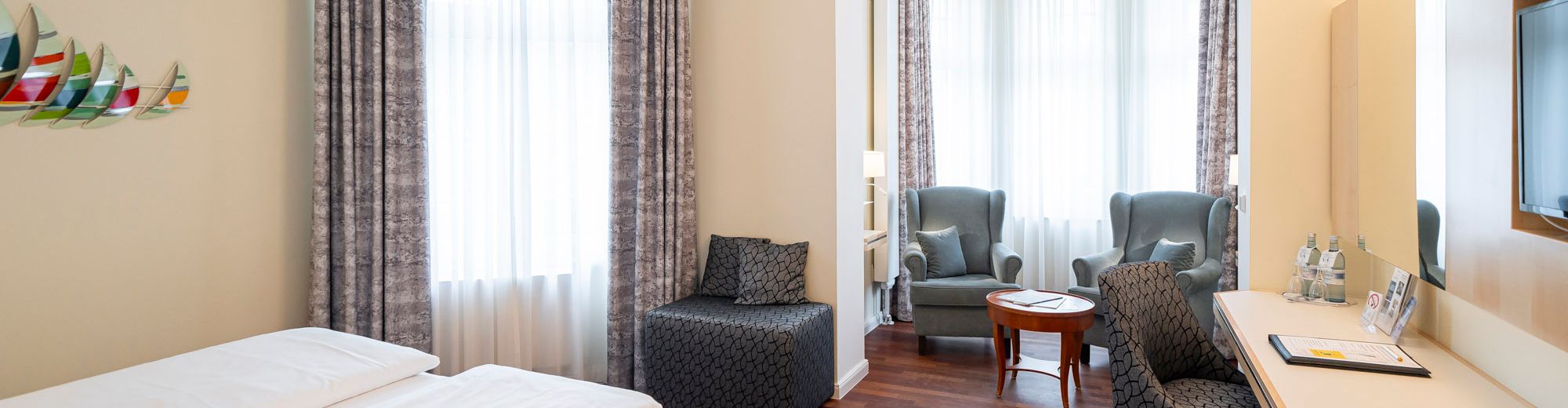 Doppelzimmer mit Erker und großen Fenstern.