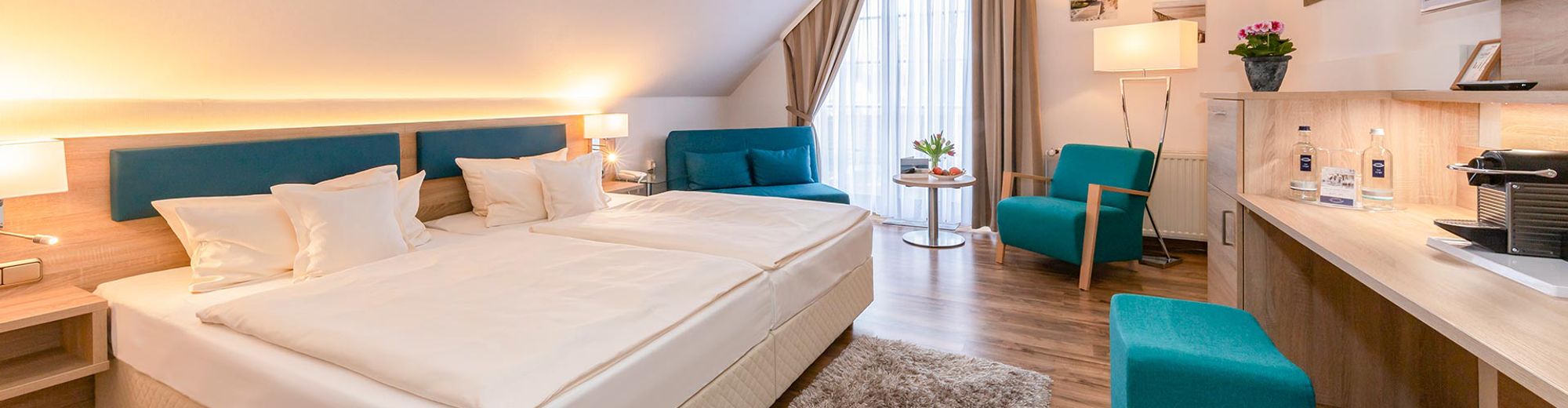 Doppelzimmer mit Bett und Polstermöbeln