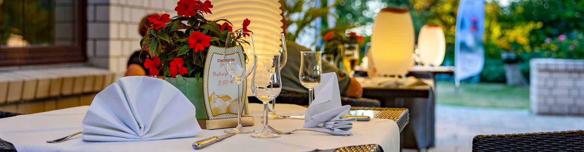 Gedeckter Tisch auf der Terrasse des Restaurants mit Tischbeleuchtung