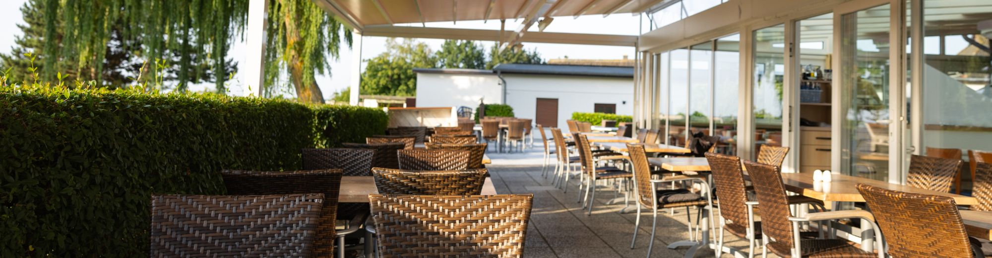 Terrasse mit brauen Korbstühlen und Tischen