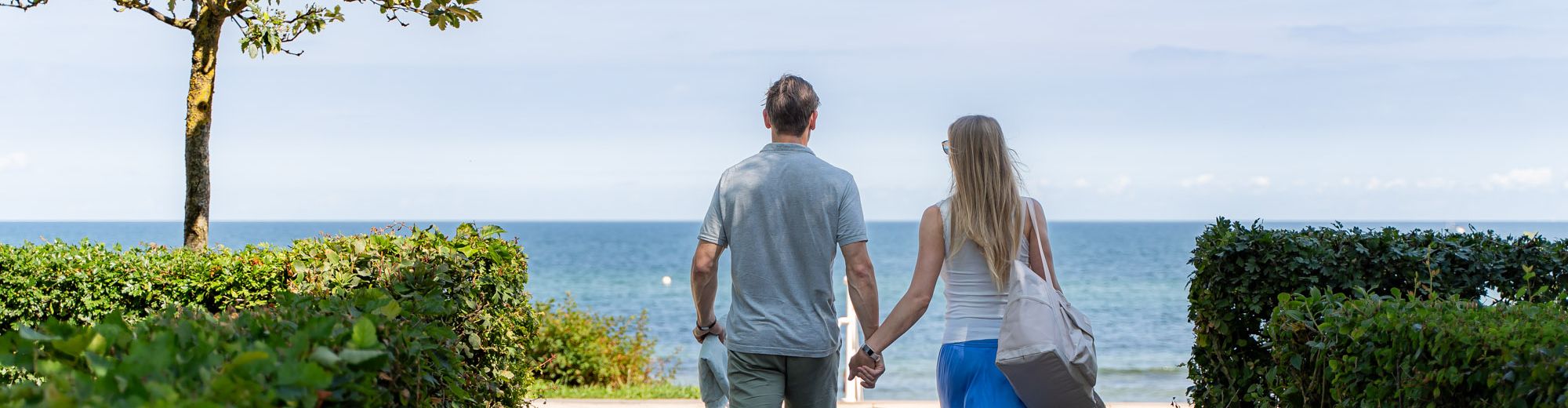 ein Paar schlendert den Weg entlang zum Strand