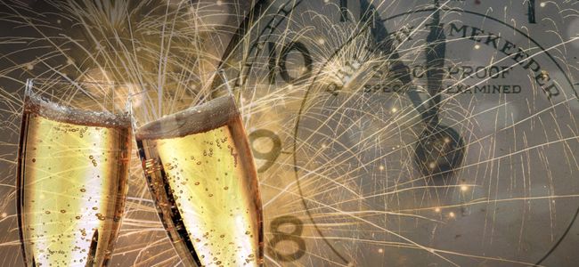 2 gefüllte Sektgläser vor einer Uhr und Feuerwerk