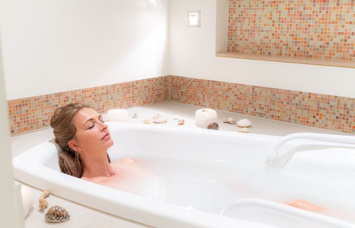 Eine Frau entspannt in einer Sprudelbadewanne